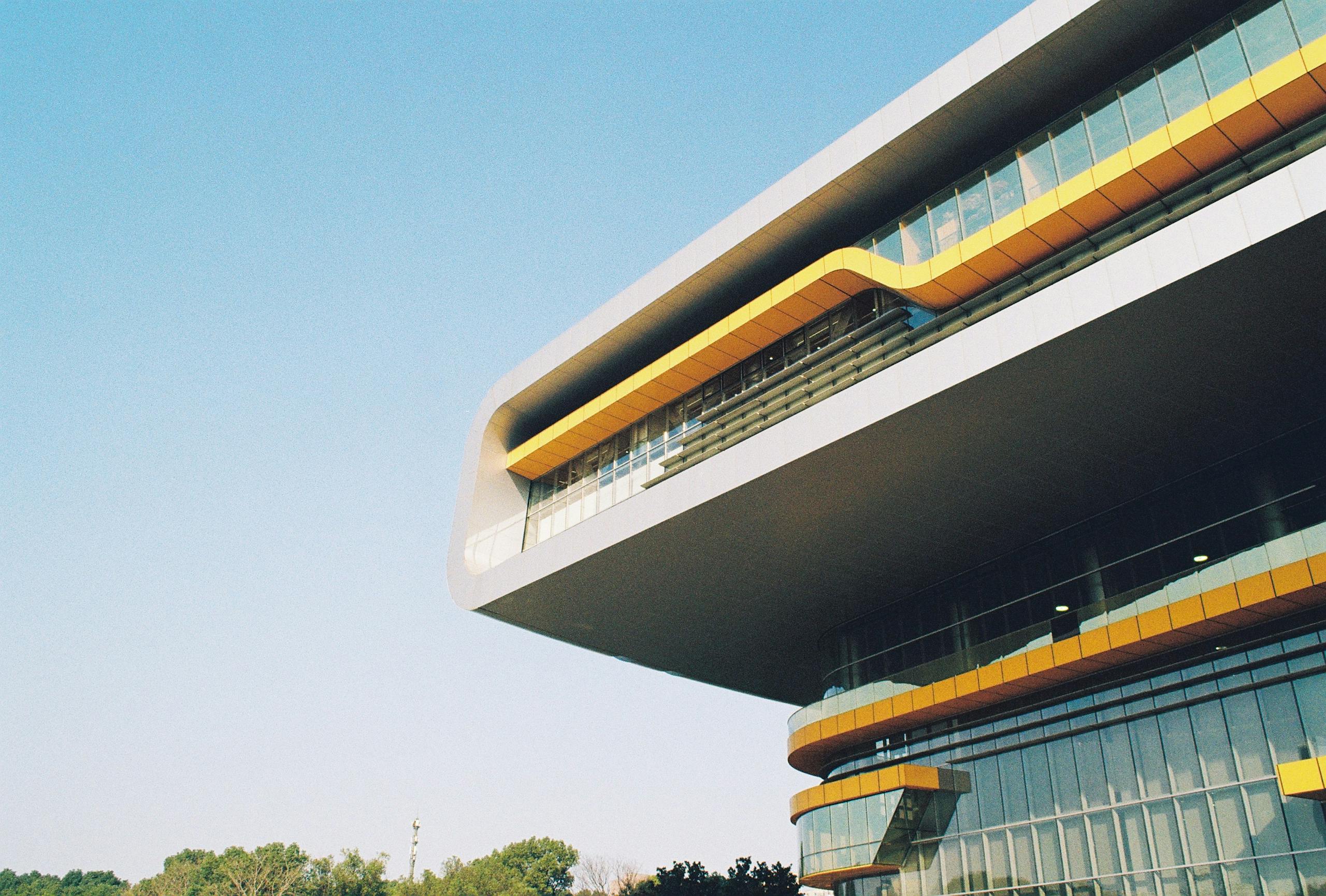 Dynamic modern building design showcasing bold, futuristic architecture under a clear sky.